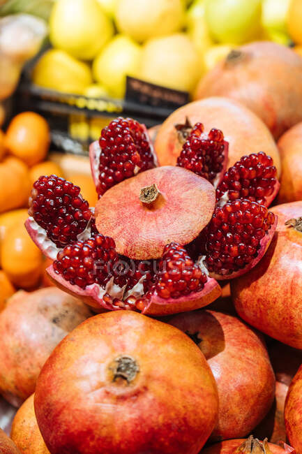 Melograno fresco carino messo su mucchio di frutta su bancarella in negozio di alimentari — Foto stock