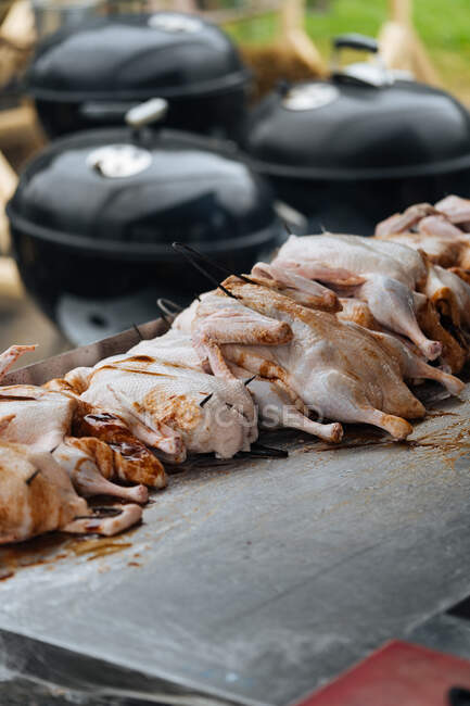 Dall'alto di pollo di cottura con fumo su griglia in bancarella di mercato — Foto stock