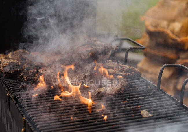 Du dessus de la cuisson du poulet avec de la fumée sur le gril dans la stalle du marché — Photo de stock