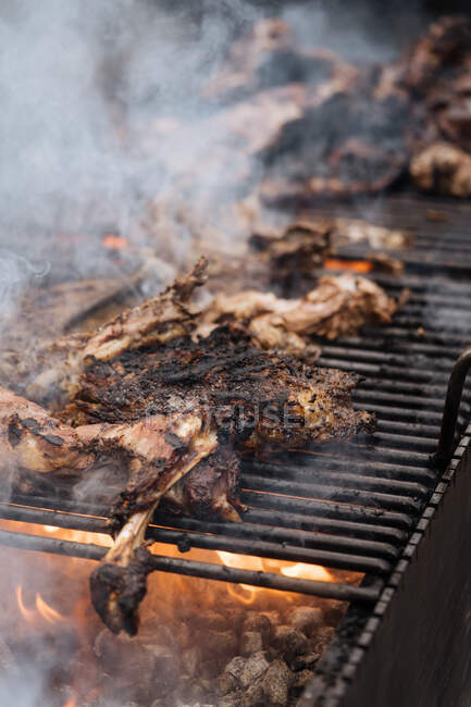 Сверху приготовление курицы с дымом на гриле в ларьке — стоковое фото