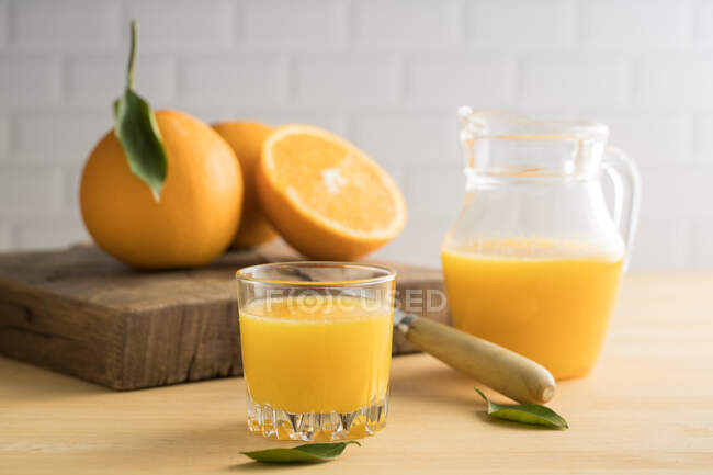 Jugo de naranja en vaso sobre la mesa - foto de stock