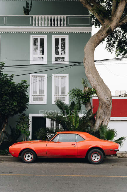 Red car parked at house in street — Stock Photo