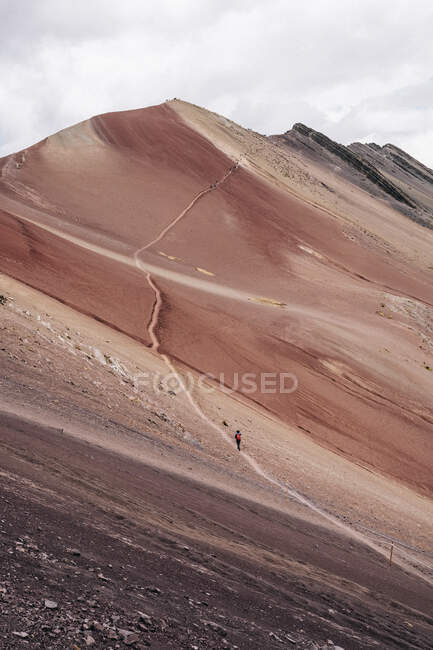 Amazing colorful rocky mountain and tourist hiking on curving road in bright day — Stock Photo