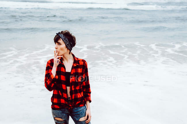 Woman smoking cigarette on beach — Stock Photo