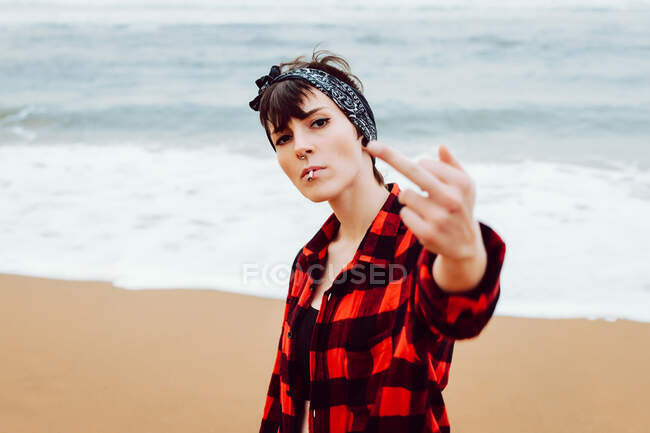 Woman showing middle finger on beach — Stock Photo