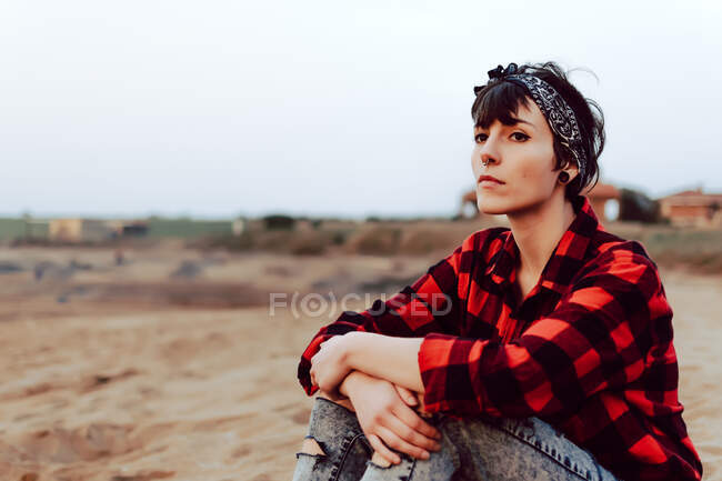 Nachdenkliche Hipster-Frau sitzt am Sandstrand — Stockfoto