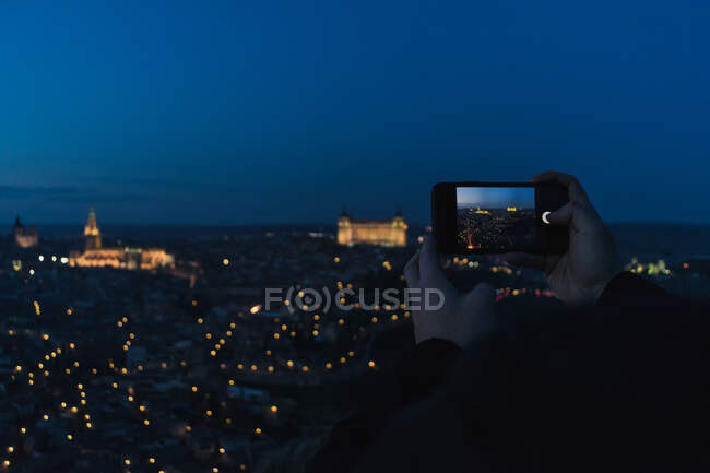 Photographe prenant une photo de la vieille ville au crépuscule — Photo de stock