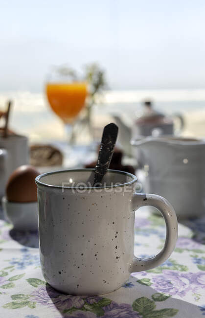 Homemade full brunch breakfast in sunlight with tea or coffee on a mug, cooked eggs, and orange juice — Stock Photo