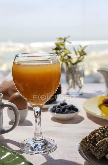 Petit déjeuner complet fait maison au soleil avec un verre de jus d'orange, de bleuets, d'œufs et de pain — Photo de stock