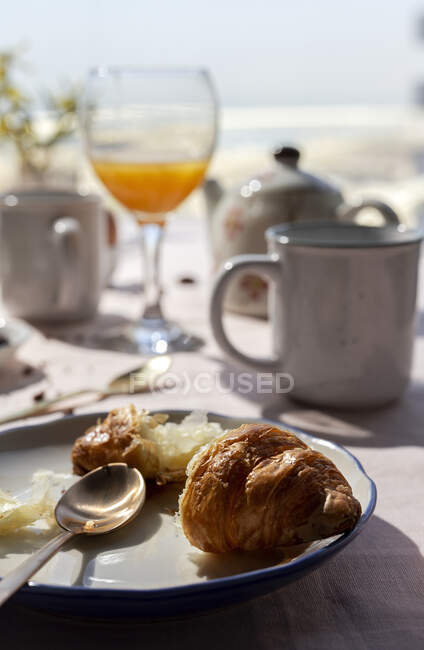 Homemade full brunch breakfast in sunlight with croissants, tea, coffee and orange juice — Stock Photo