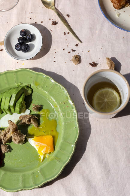 Homemade full healthy breakfast in sunlight with eggs, avocado, strawberries, blueberries, sponge cake, croissants, toast, tea, coffee and orange juice — Stock Photo