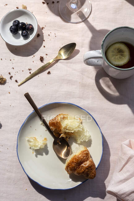From above top view of homemade full brunch breakfast in sunlight with croissants, cooked eggs, tea, coffee and orange juice — Stock Photo