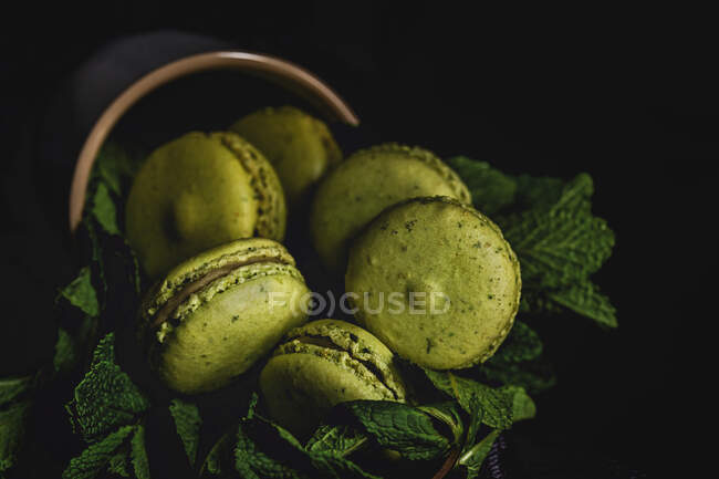 Macarons verts faits maison vert avec menthe sur fond foncé. Nourriture sombre . — Photo de stock