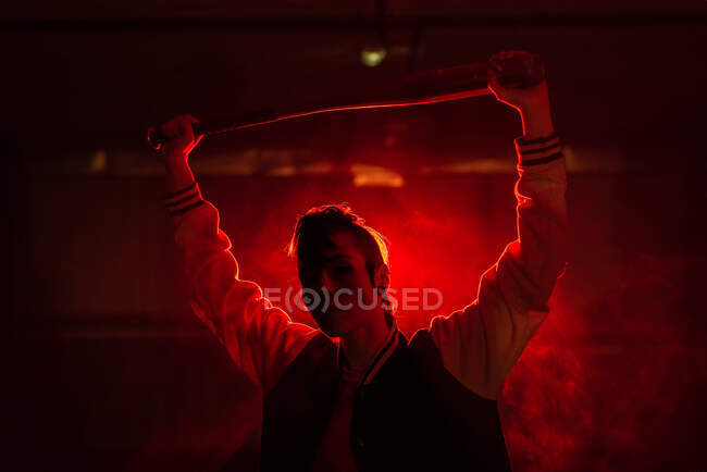 Mujer rebelde en chaqueta casual con piercing y peinado moderno con  murciélago entre luz roja colorida y vapor — poder, golpeó - Stock Photo |  #357482198