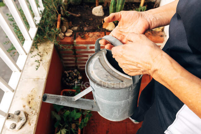 Анонимные садовницы поливают растения дома — стоковое фото