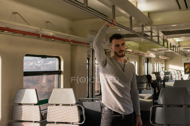 Focused young male passenger riding metro in daytime — Stock Photo