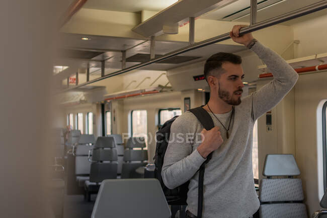 Focalizzato giovane passeggero maschile guida metropolitana durante il giorno — Foto stock