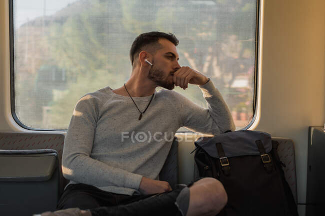 Продуманий молодий пасажир-чоловік слухає музику в машині метро — стокове фото
