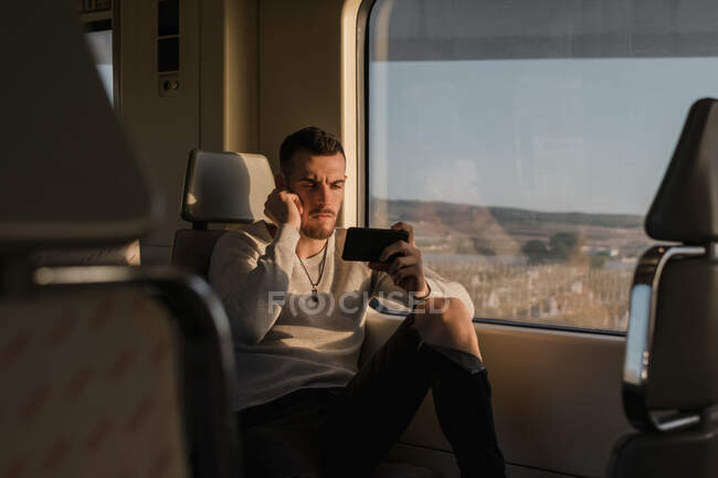 Молодий пасажир користується смартфоном у метро. — стокове фото