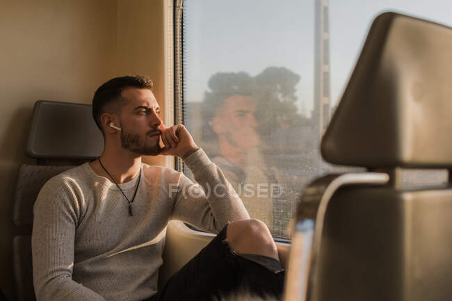 Задумчивый молодой пассажир, слушающий музыку в вагоне метро — стоковое фото