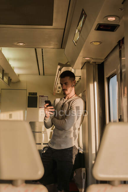 Jovem passageiro do sexo masculino usando smartphone no metrô — Fotografia de Stock