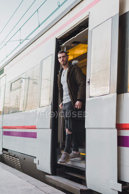 Homem concentrado saindo do vagão de trem — Fotografia de Stock