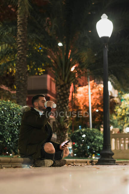 Serious young man using smartphone in street — Stock Photo