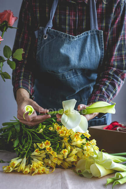 Неузнаваемая женщина-профессиональный флорист делает букеты различных типов. Розы. Желтые цветы. Ковес — стоковое фото