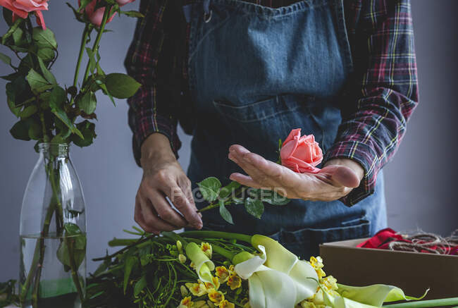 Unerkennbar weibliche professionelle Floristin, die Sträuße verschiedener Art herstellt. Rosen. Gelbe Blumen. Buchten — Stockfoto
