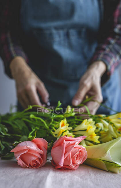 Unrecognizable female professional florist making bouquets of various types. Roses. Yellow flowers. Coves — Stock Photo
