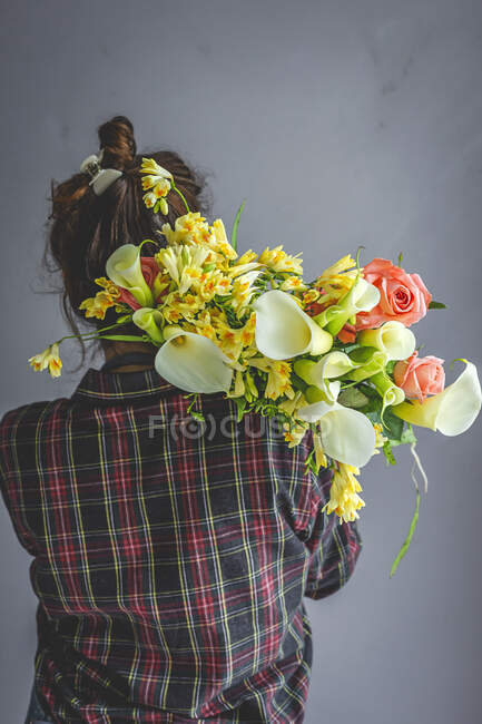 Florista profesional femenina irreconocible haciendo ramos de varios tipos. Rosas. Flores amarillas. Calas - foto de stock