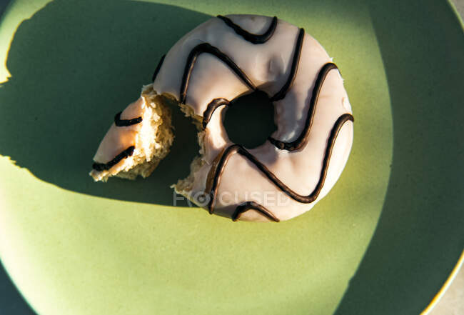 Donuts con glaseado y chocolate en el plato - foto de stock