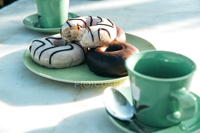Composition of aromatic hot drink and tasty donuts on table — Stock Photo