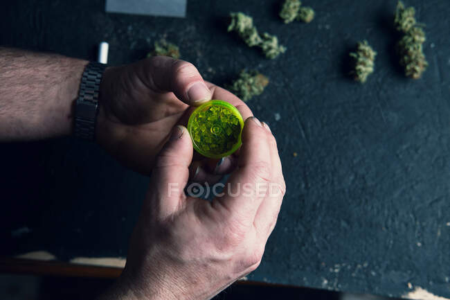 Fumador masculino irreconocible haciendo marihuana conjunta - foto de stock