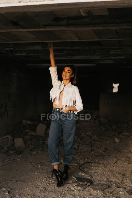 Sensible joven modelo femenino dentro de edificio abandonado - foto de stock