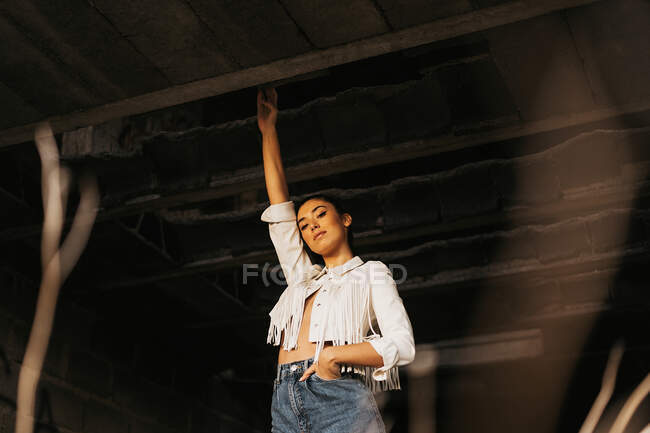 Sensible joven modelo femenino dentro de edificio abandonado - foto de stock