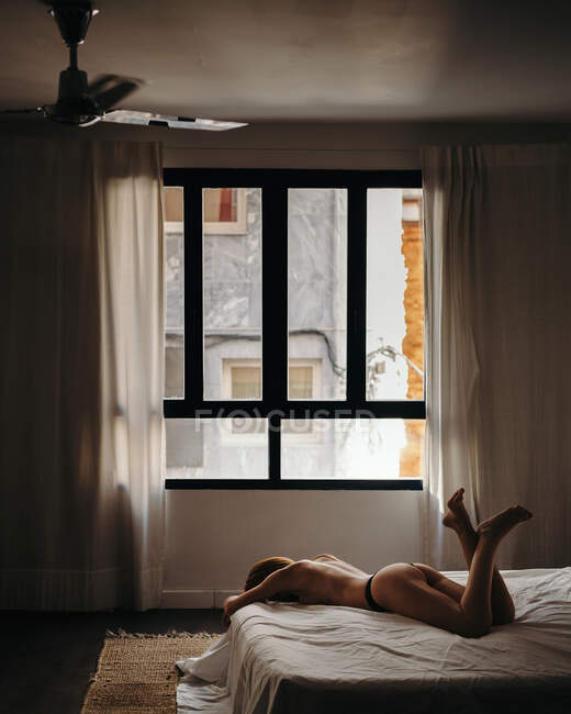 Magro donna seducente in topless sul letto — Foto stock