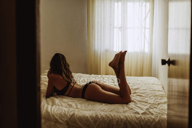 Seductive young woman on bed in morning — Stock Photo