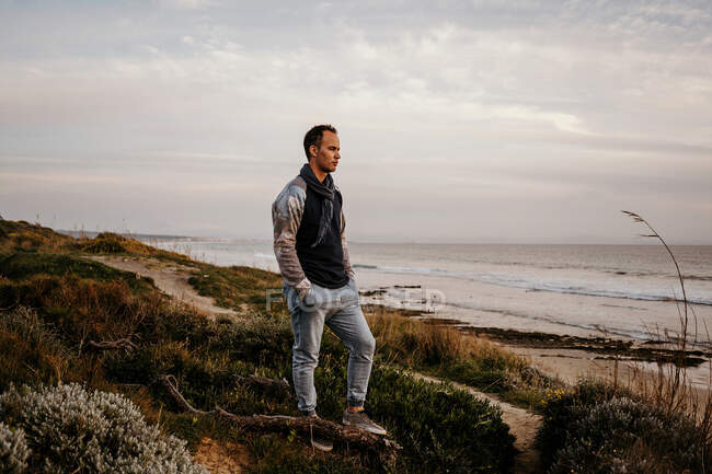 Самотній чоловік розглядає морський пейзаж в похмурий день — стокове фото