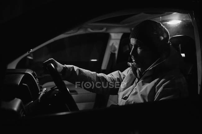 Homem focado dirigindo carro à noite — Fotografia de Stock
