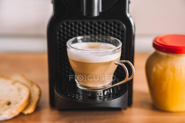Frischer Latte-Kaffee mit Milch auf der Kaffeemaschine in der modernen Küche — Stockfoto