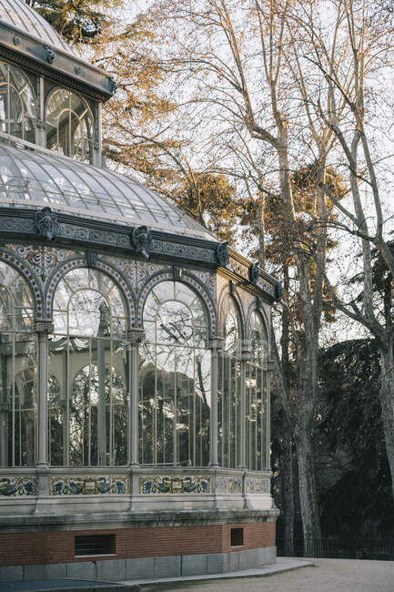 Геометричний древній замок зі скляними вікнами, що відображають дерева, Паласіо де Крістал, Парк Ретіро, Мадрид, Іспанія. — стокове фото