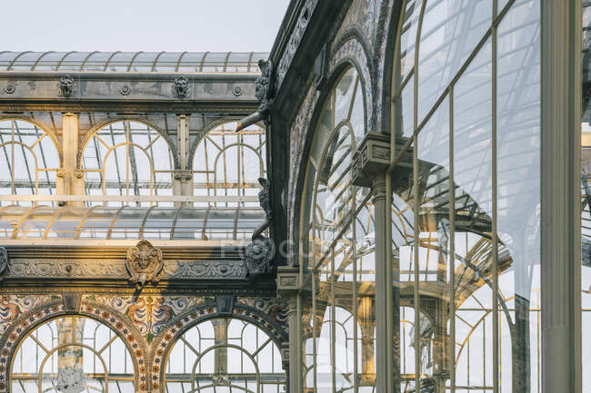 Antico castello geometrico con vetrate che riflettono alberi, Palacio de Cristal, Parco del Retiro, Madrid, Spagna — Foto stock