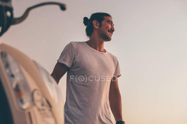 Позитивний чоловік з мотоциклом, що стоїть на морі — стокове фото