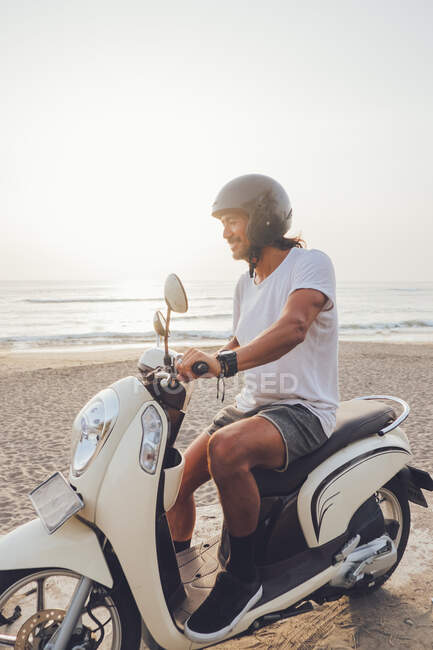 Biker allegro sulla spiaggia di sabbia — Foto stock