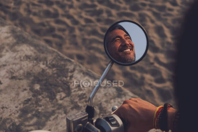 Happy man riding bike on beach — Stock Photo