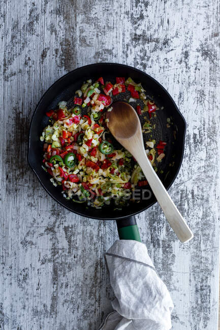From above garlic with pepper and onion fried gently in pan on kitchen — Stock Photo