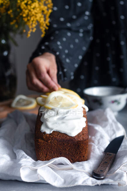 Hausfrau dekoriert Kuchen mit Zitronenscheiben — Stockfoto