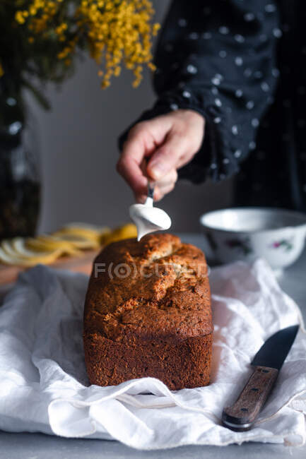 Femme mettant de la crème fouettée sur le gâteau — Photo de stock