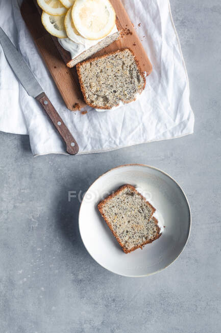 Pieces of lemon and poppy seeds cake served on white plates — Stock Photo